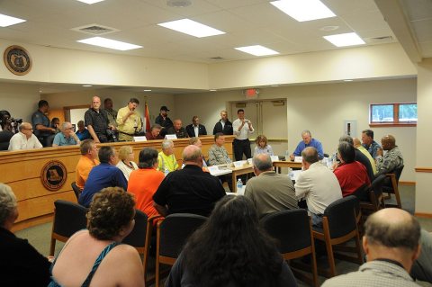 Government officials from several counties meet with Missouri Gov. Jay Nixon, seated at right in blue shirt, and Missou…