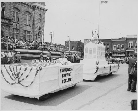 A Southwest Baptist Float passes in front of the reviewing platform (in the distance) on which President Harry S.... - …
