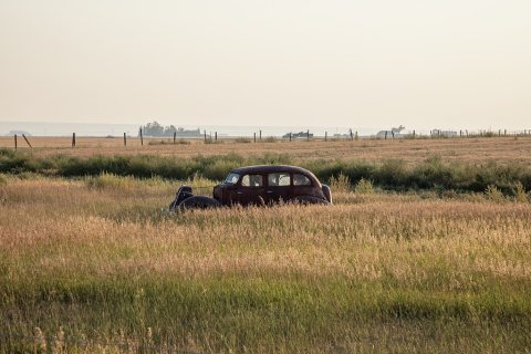 Something is definitely missing from this vintage car in a hayfield near the town of Conrad, Montana