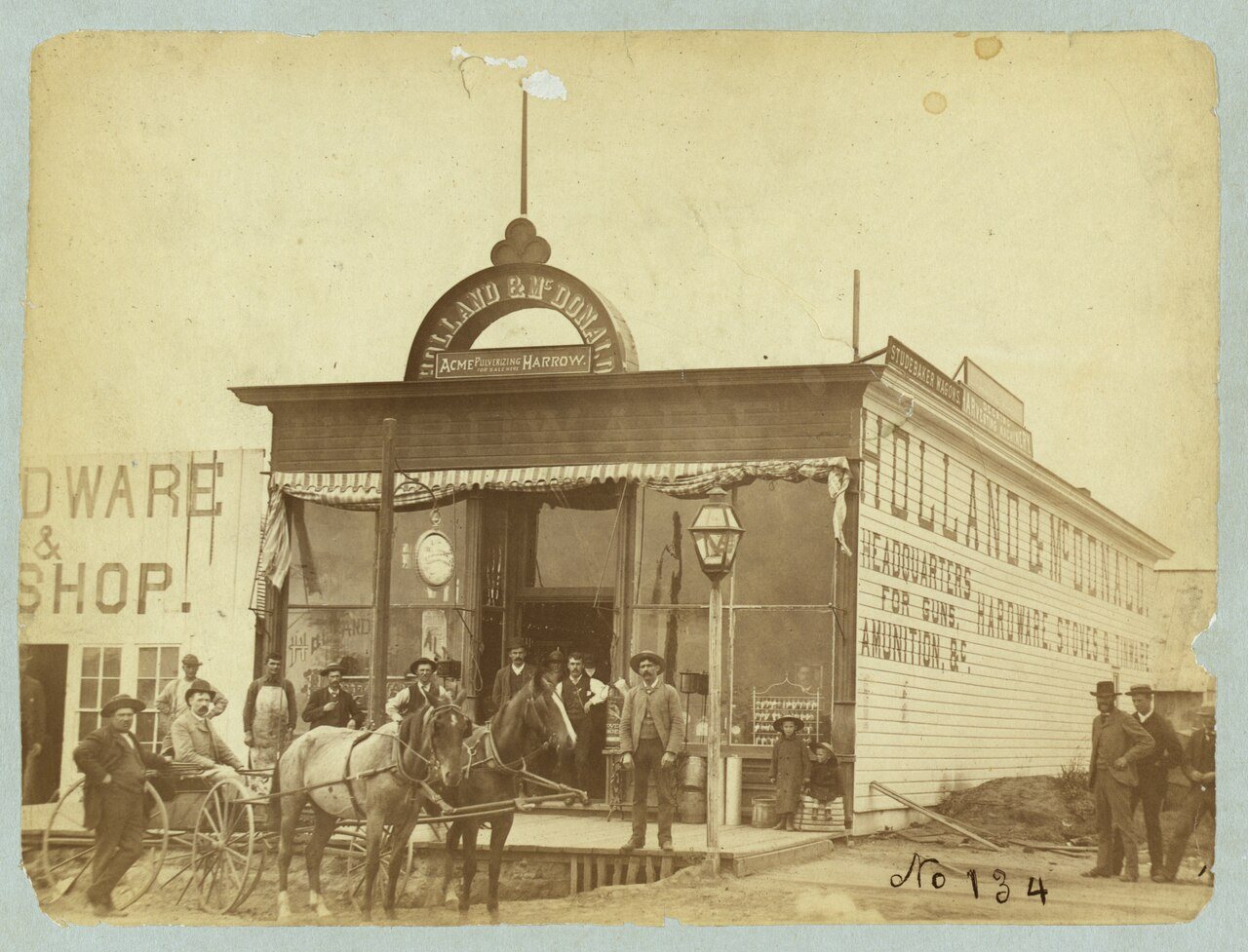 Group posed in front of the Holland & McDonald hardware store