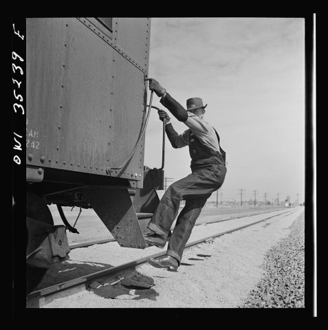 Texico, New Mexico. Conductor E.K. Hill about to get off the caboose as an Atchison, Topeka and Santa Fe train pulls in…