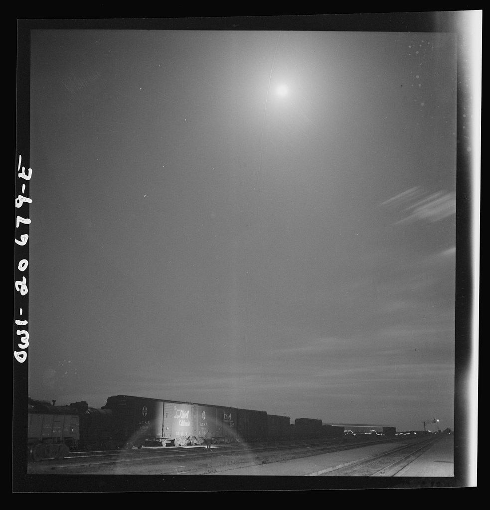 Vaughn, New Mexico. Train inspector at work in the Atchison, Topeka and Santa Fe Railroad yard, between Clovis and Vaug…