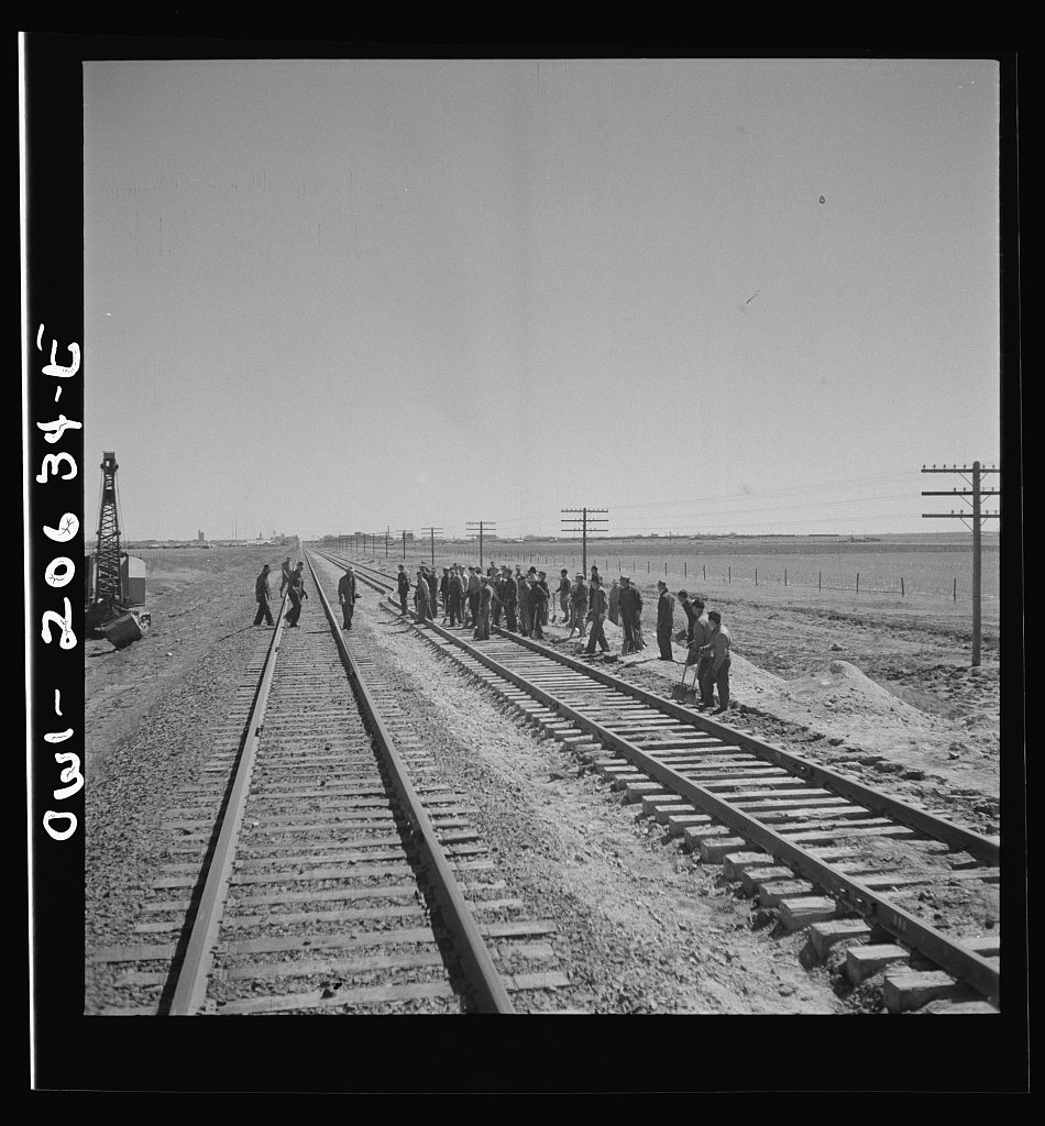 Untitled photo, possibly related to: Clovis, New Mexico. Passing a section gang at work on the outskirts along the Atch…