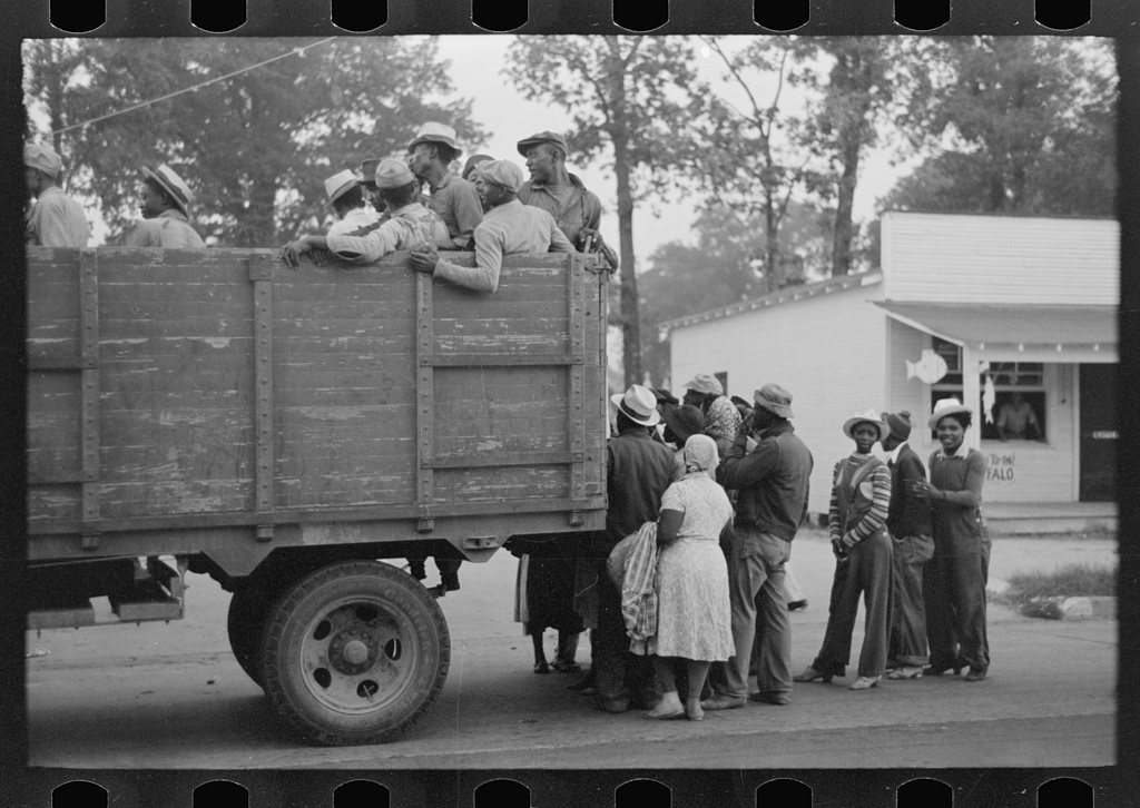 Cotton pickers being loaded onto truck for transportation to fields