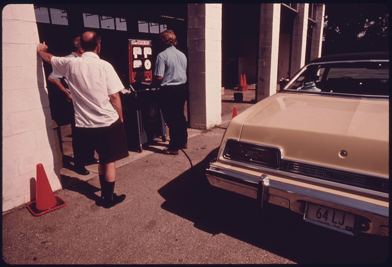 TWO MOTORISTS WATCH AS CARBON MONOXIDE AND HYDROCARBON EMISSION READINGS ARE REGISTERED ON THE EXHAUST ANALYZER. THE...…