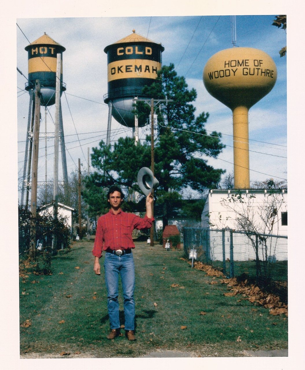 Larry Long standing in front of Okemah Water Towers