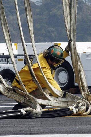 US Navy 070502-N-4053P-068 Lt. Kyle Beahan, of Estacada, Ore., inspects an aircraft barricade during flight deck drills…