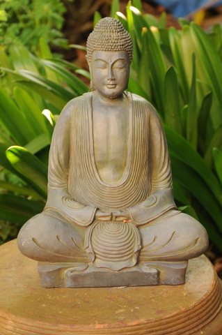 Formal folds of his garment, Lord Buddha meditates, inquiring within, statue on a platform, garden, South Bay Vajrayana