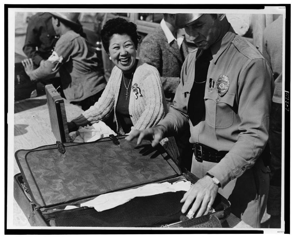 Japanese relocation, California. All baggage is inspected before newcomers enter the Santa Anita Park Assembly Center a…