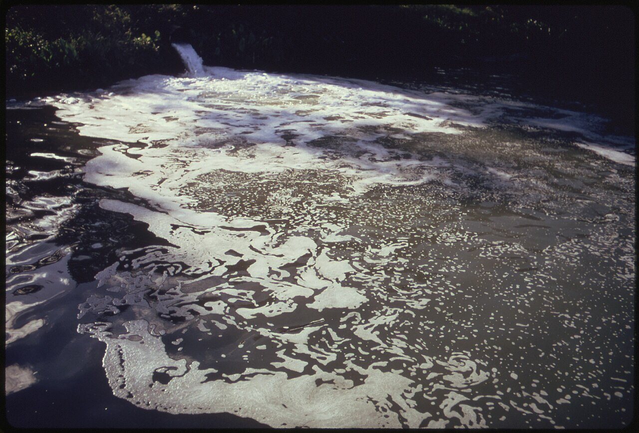 CLOSEUP OF AN OUTFALL CONTAINING STYRENE EMPTYING INTO RACCOON CREEK WHICH EMPTIES INTO THE OHIO RIVER. IT COMES FROM..…