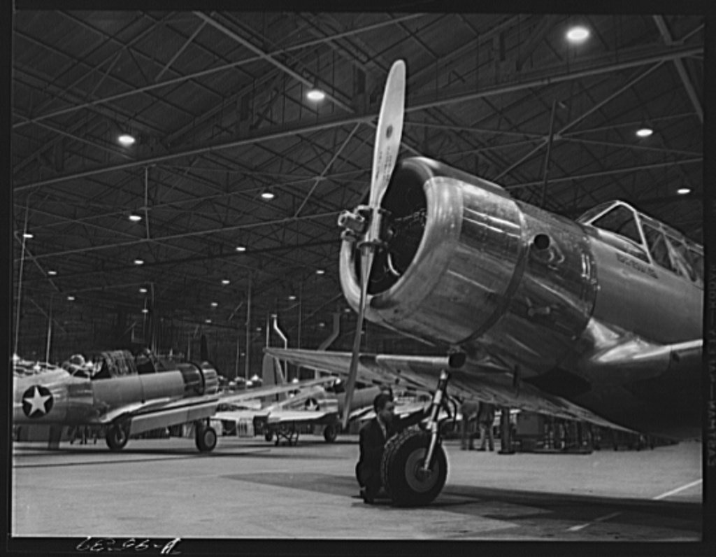 Production. BT-13A ("Valiant") basic trainers. Inspecting trainer landing gear at Vultee's Downey, California plant. At…