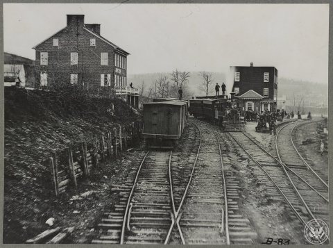 Hanover Junction Pennsylvania, 1863, railroad yards. Detail of tracks, engine, boxcar, and crowd