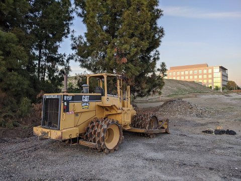 Caterpillar 815F soil compactor on site in Sunnyvale, facing left