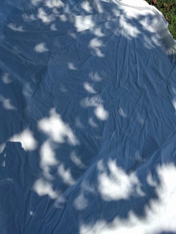 Solar eclipse shadows on a groundsheet