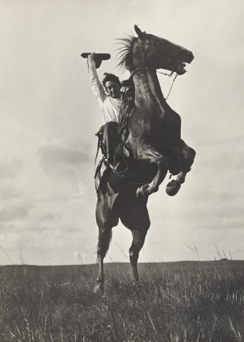 Photographer Erwin E. Smith riding a "sunfisher" and he is not pulling leather, Bonham, Texas, 1908
