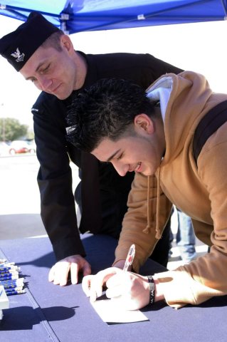US Navy 050228-N-3750S-001 Journalist 2nd Class Jason Heaver, left, Navy Recruiting District Houston Public Affairs Off…