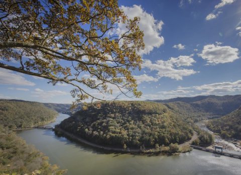 View from above of a dramatic horseshoe bend of the New River, and an interesting entrance and egress of a railroad lin…