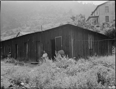 A row of garages which have been converted by the company into housing for single men, one room the size of an... - NAR…