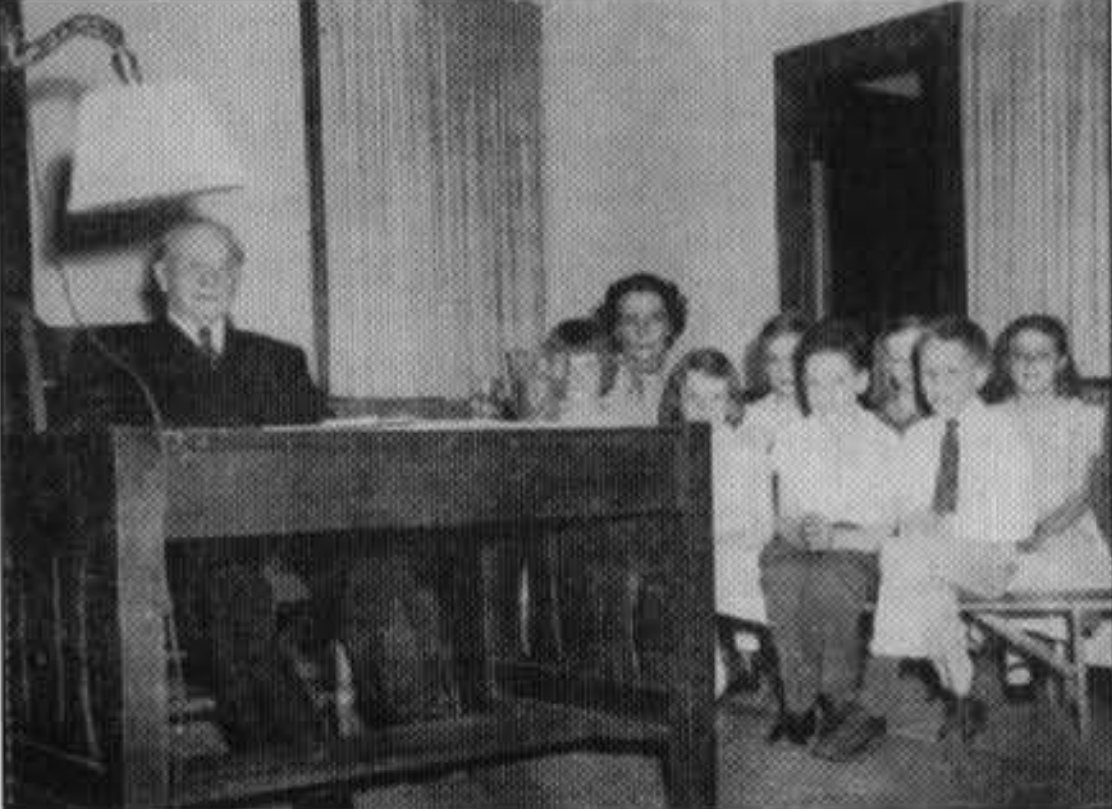Lewis S. Mills reading to schoolchildren in