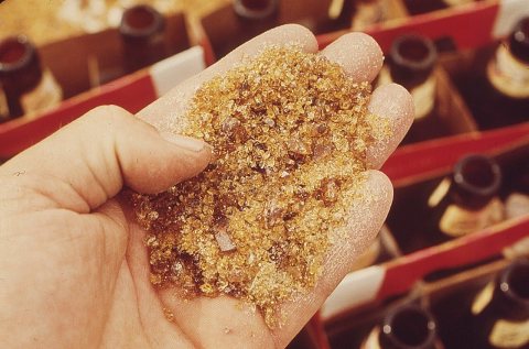 CLOSEUP OF BEER BOTTLES CRUSHED INTO FINE GLASS. THIS MIXTURE IS FED INTO THE GLASS FURNACE AND NEW BOTTLES ARE MADE...…