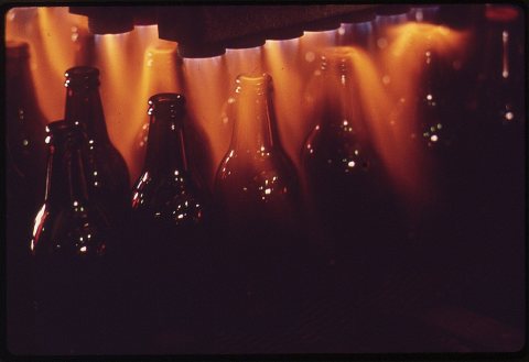 RECYCLED BEER BOTTLES RECEIVE HEAT TREATMENT PRIOR TO FINAL PACKAGING. ONE PART OF A NEW GLASS RECYCLING PROCESS FOR...…