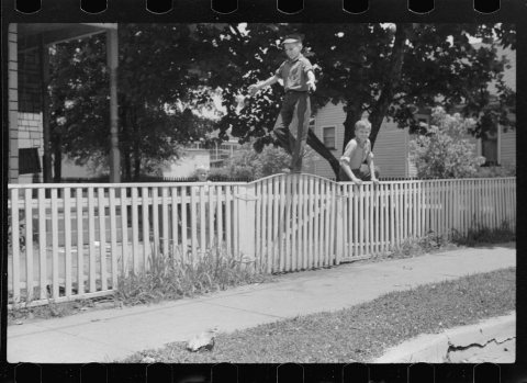 Untitled photo, possibly related to: Boys walking fence. Washington, Indiana