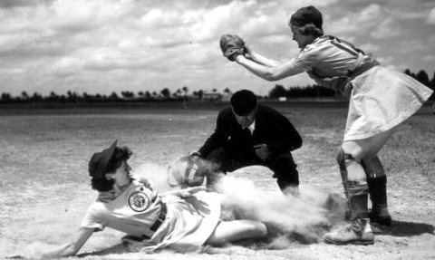 All American Girls Professional Baseball League player Marg Callaghan sliding into home plate as umpire Norris Ward wat…