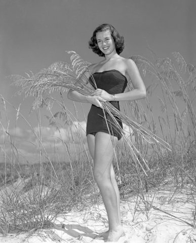 Rosemary Carpenter posing with a handful of sea-oats on