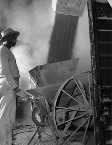A mill worker watches over the loading of powder fine phosphate