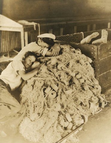 Boys sleeping on idle fishing nets in