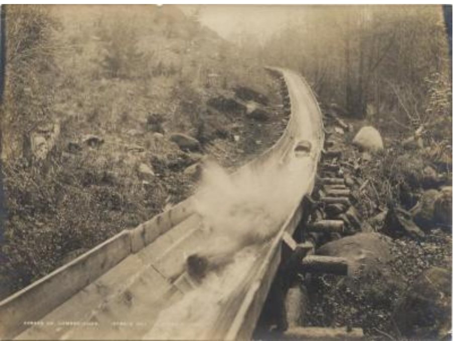 View of logs traveling down Rogers Lumber Company slide at Spruce Hill, in the Adirondack Mountains, probably near the …