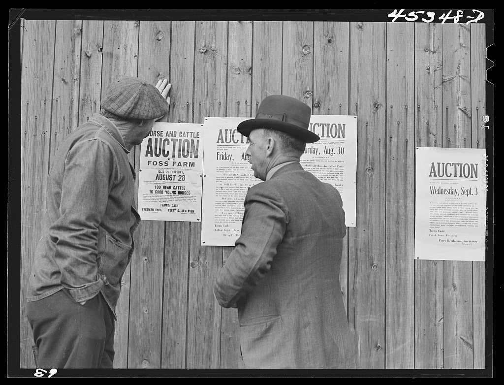 Farmers reading auction notices of farms in the Pine Camp expansion area at an auction of the Ingalls farm near Antwerp…
