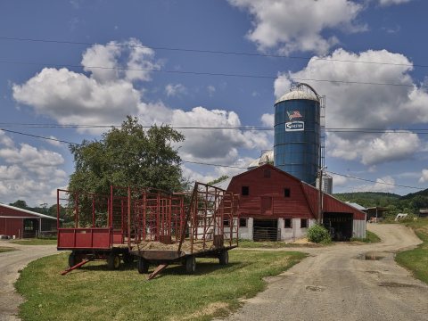 Hay wagons outside a dairy barn near Candor, New York