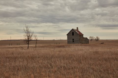 A slightly leaning, abandoned house appears on the prairie near Tioga, North Dakota