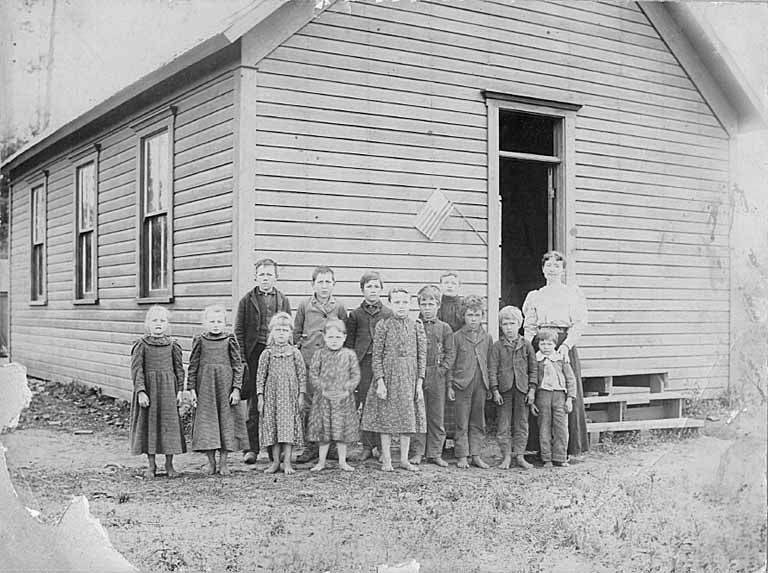 Children with teacher outside schoolhouse at Dry Creek Ridge, near Troy, Idaho, 1901