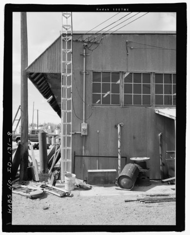 AFRD WAREHOUSE, EAST SIDE DETAIL SHOWS CONNECTION OF LEAN-TO TO WALL. FACING WEST. NOTE THE PROFILE OF THE METAL AWNING…