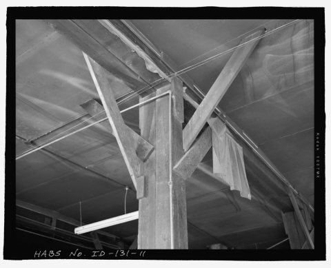 AFRD WAREHOUSE, INTERIOR DETAIL OF RAFTER SUPPORT POST TIMBER AND METHOD OF BRACING. THE BRACES PENETRATE THE SHEET ROC…