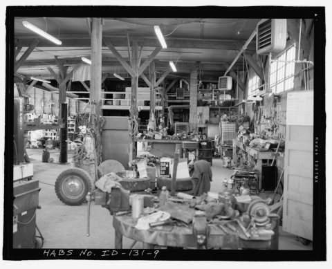 AFRD WAREHOUSE, INTERIOR, FACING WEST. TWO ROWS OF ORIGINAL WOOD POSTS SUPPORT CEILING RAFTERS. SHEETROCK ON CEILING AN…