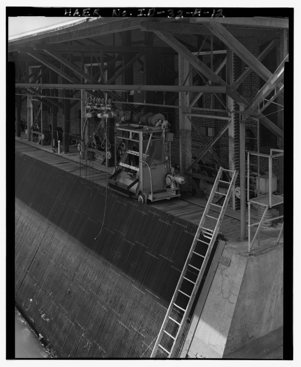 CLOSE-UP OF THE CURRENT TRASH RAKE-LIFTING MECHANISM (CALLED 'JAWS' BY THE PRESENT OPERATORS), LOOKING WEST. THIS EQUIP…