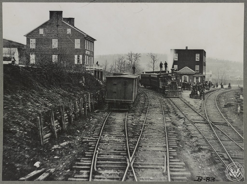 Hanover Junction Pennsylvania, 1863, railroad yards. Detail of tracks, engine, boxcar, and crowd
