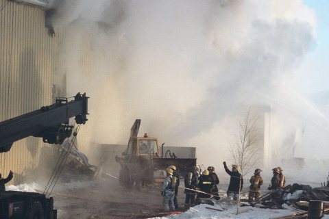 Firefighters battle a blaze caused by a propane leak at the Adak warehouse. Firemen are using some of the salvaged equi…