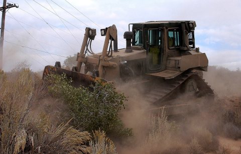 US Navy 071027-N-7206K-007 A bulldozer attached to Amphibious Construction Battalion (ACB) 1, clears away dry shrubs in…