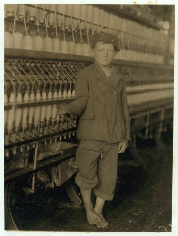 Young doffer boy at machine in Massachusetts Mills