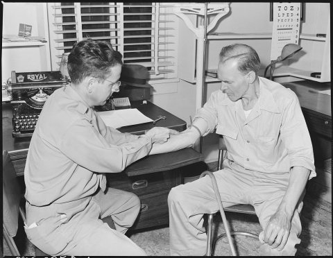 Dr. R. S. Howard, company doctor, giving intravenous injection of Aminophylline for miner's asthma to James E. Lee.... …