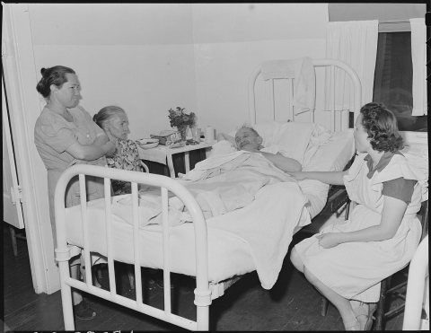 Dan Moore, miner, in company hospital receiving visit from family members. He has double hernia. Black Mountain... - NA…