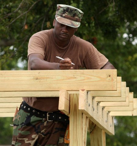 US Navy 090613-N-9968P-015 Builder 1st Class Dwayne Brown marks the placement of wood slats on a piece of playground eq…