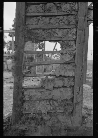 Detail of construction of old house; note the wooden cross lath. The construction material composed of mud and native m…