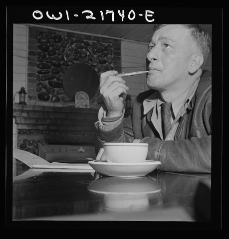 Pearlington, Mississippi. James Hall, truck driver, stopping for a cup of coffee and working on his log