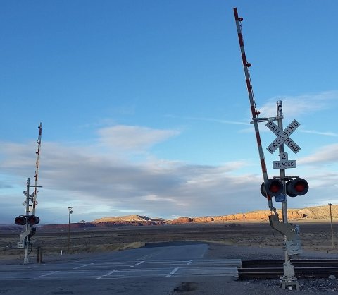 Railway crossing with red cliffs in background