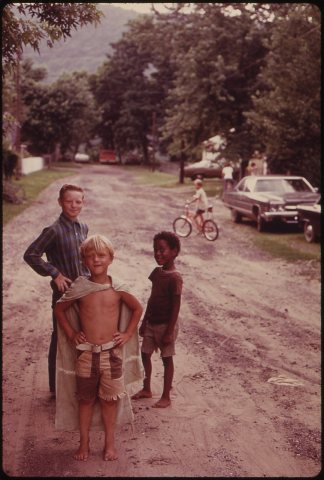 CHILDREN PLAY IN AN UNPAVED STREET IN